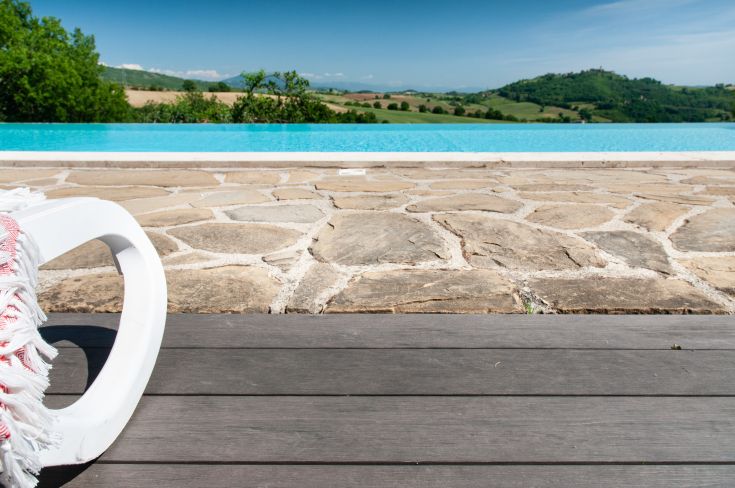 Edificio circondato da aree verdi, con piscina e ampia vista sulle colline umbre.