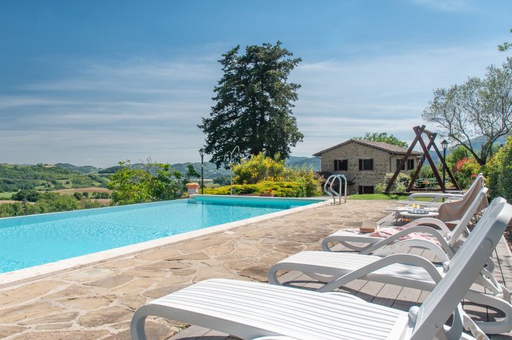 Una villa con piscina circondata da giardino, ideale per momenti di relax nella natura.