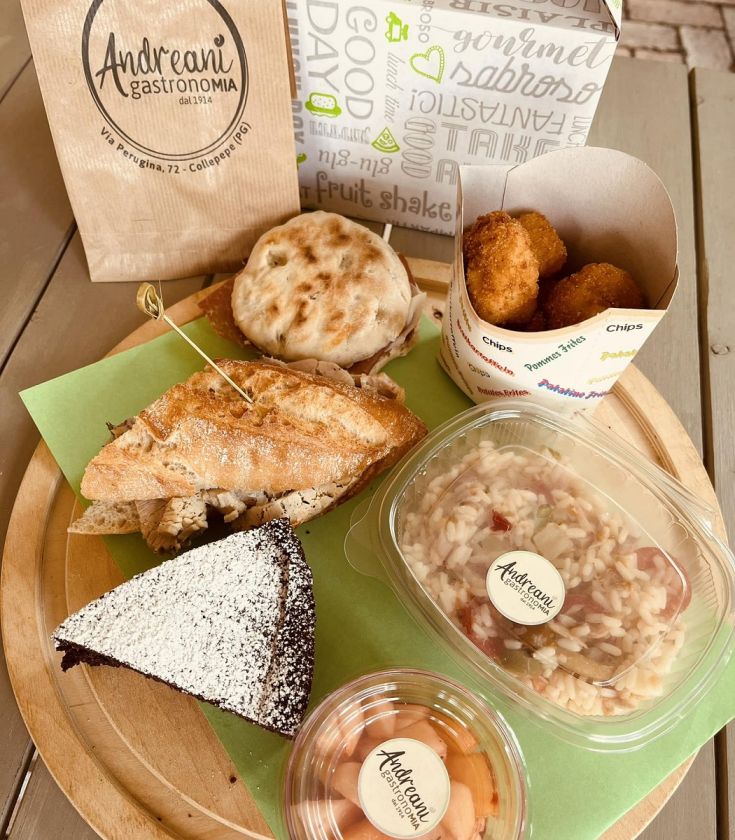 Un assortimento di piatti tipici, tra cui panini, risotto e dolce della tradizione locale.