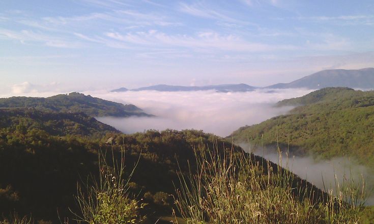 Mountain panorama with clouds creating a serene atmosphere over the landscape.