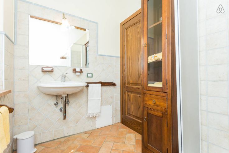 Ein eingerichtetes Badezimmer mit hellen Fliesen und Holzmöbeln, ideal für entspannende Momente.