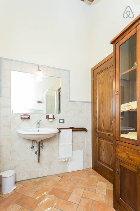 Ein gut beleuchtetes Badezimmer mit einem Holzwaschbecken und Schrank. Ein gemütlicher und ruhiger Raum.