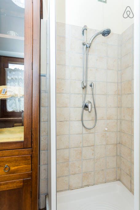 Moderne Dusche in einer eleganten Umgebung, mit hellen Fliesen und natürlichem Licht.