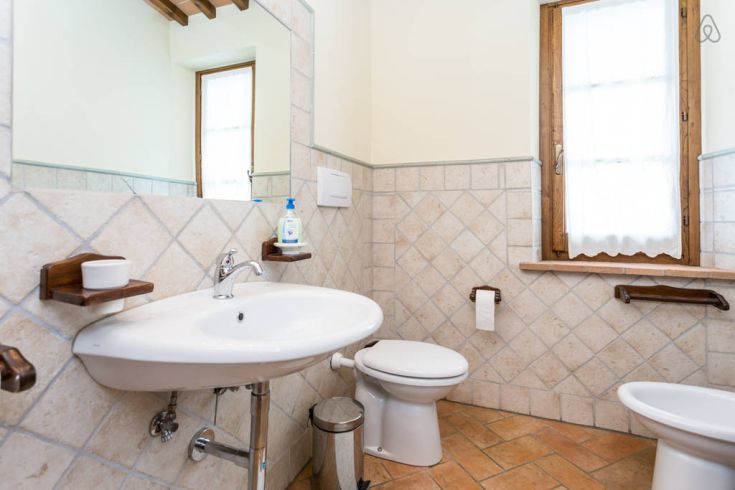 Ein einfaches Badezimmer mit hellen Fliesen und Holzelementen, perfekt für entspannende Momente.