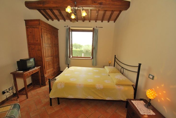 Gemütliches Zimmer mit Blick auf den Garten, ausgestattet mit einem Doppelbett und TV, ideal für einen ruhigen Aufenthalt.