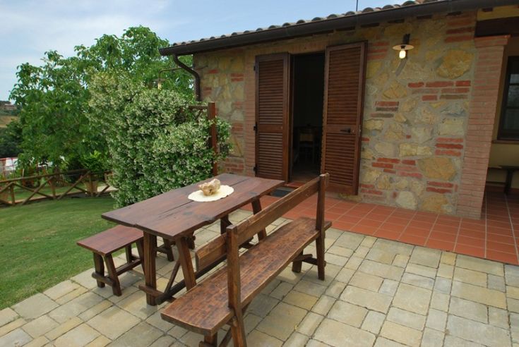 Ein Außenbereich mit einem Holztisch, umgeben von einem Garten, perfekt für entspannende Momente.