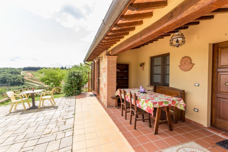 Ein ruhiger Außenbereich mit einem Tisch und Stühlen, umgeben von natürlicher Landschaft.