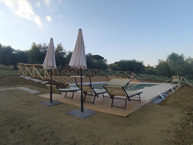 Ein ruhiger Poolbereich, umgeben von Grün, ideal für Entspannung und Ruhe.