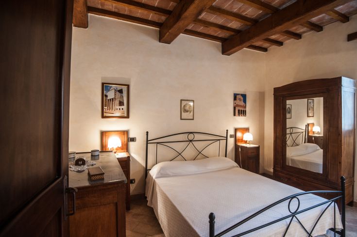 Spazio semplice e confortevole, dotato di un letto matrimoniale e mobili in legno chiaro, ideale per un riposo tranquillo.