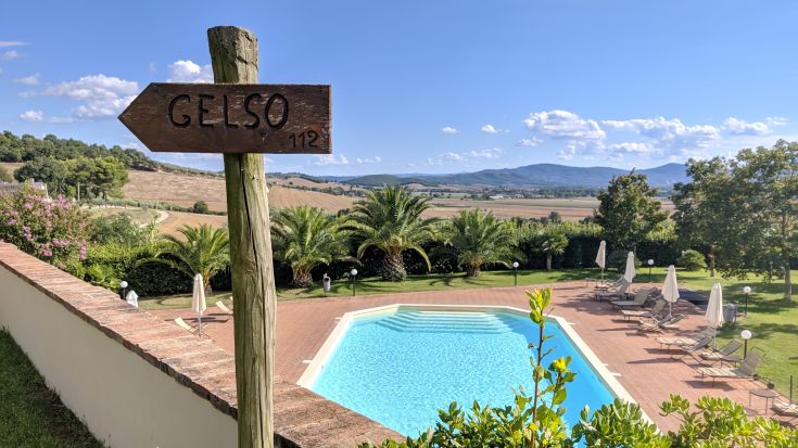 Un agriturismo immerso nella natura, dotato di piscina e con una scena sulle colline circostanti.