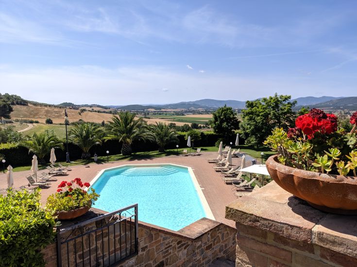 Un agriturismo con piscina circondato da verdi colline umbre.
