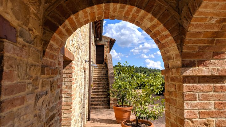 Un arco realizzato in mattoni che si integra in un ambiente rurale tranquillo.