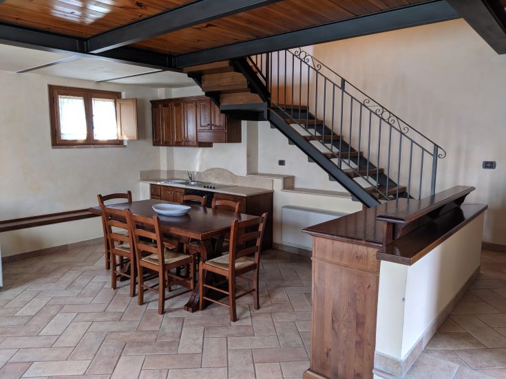 Ambiente semplice di un agriturismo con zona cucina e area per i pasti.