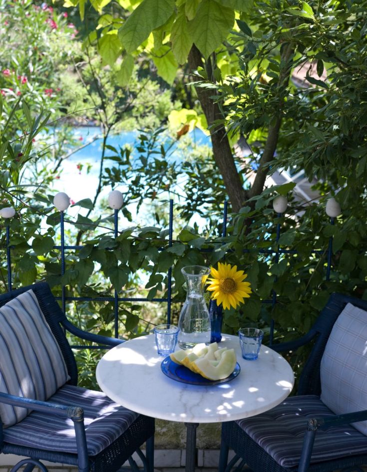 Un angolo di relax con panorama sulla piscina, circondato da fiori e frutta fresca: un invito a rilassarsi.
