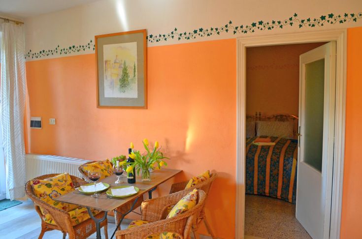 Ambiente interno accogliente di un agriturismo con tavolo predisposto per pasti, in toni caldi e dettagli semplici.