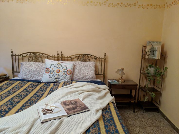 Spazio intimo con letto matrimoniale, decorazioni in stile classico e atmosfera calma.