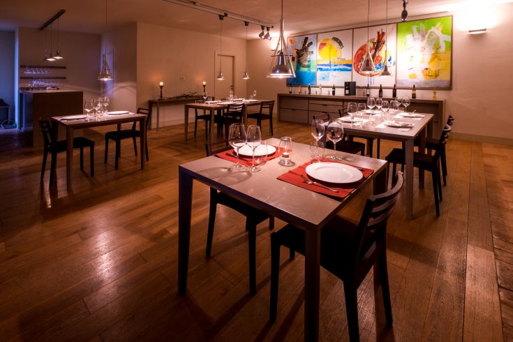 Ristorante ben arredato con tavoli apparecchiati, illuminazione soffusa e decorazioni sobrie.