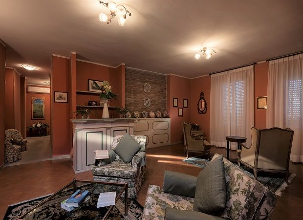 Salon accueillant avec des canapés à motifs floraux et des tons chauds, idéal pour des moments de détente.