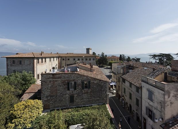 Vue panoramique de Castiglione del Lago avec des bâtiments historiques et le lac en arrière-plan.