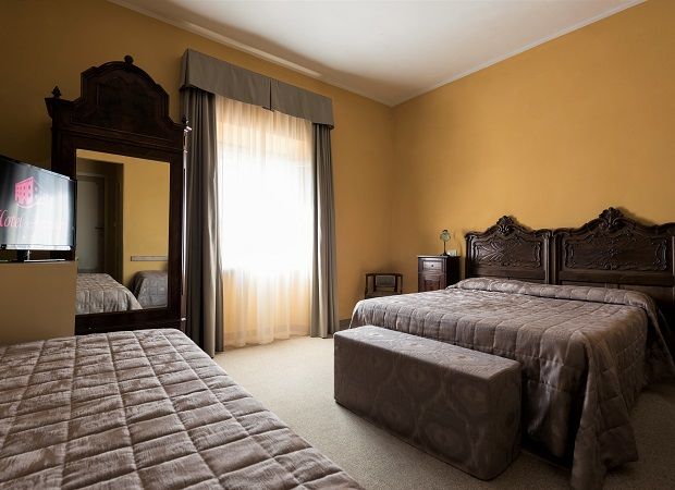 Chambre d'hôtel simple avec un décor fonctionnel et une fenêtre offrant une lumière naturelle. Idéale pour un séjour confortable.