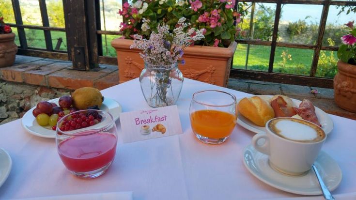 Un petit déjeuner unique avec des fruits frais, des jus et un cappuccino dans un cadre naturel.