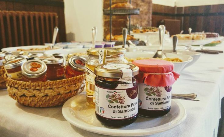 Des pots de confiture de sureau disposés sur une table pour un petit-déjeuner simple et convivial.