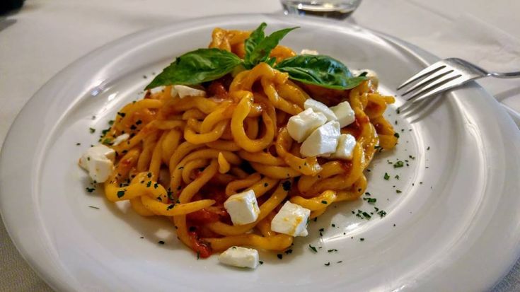 Pâtes avec des tomates fraîches, de la mozzarella et du basilic, un plat simple mais savoureux.
