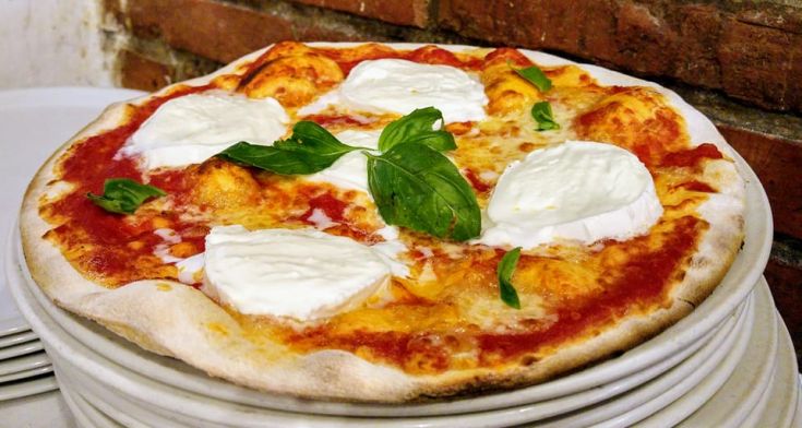 Une pizza simple avec de la mozzarella, de la sauce tomate et du basilic frais.