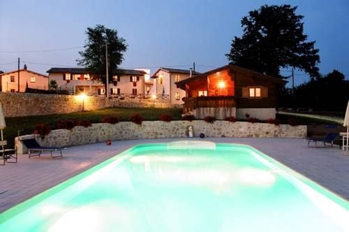 Nächtliche Szene eines beleuchteten Pools, umgeben von fernen Gebäuden und einer ruhigen Atmosphäre.