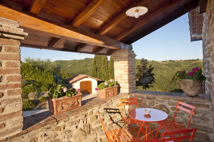 Une terrasse bien entretenue avec des plantes en fleurs et des meubles colorés.