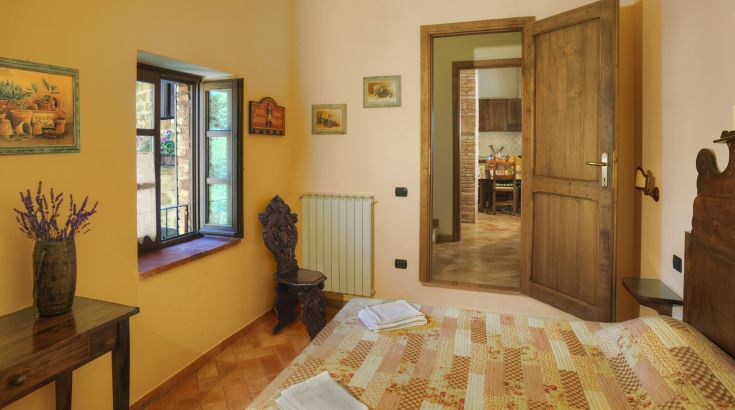 Chambre accueillante avec décoration rustique, idéale pour des moments de détente dans une ferme. Atmosphère calme.