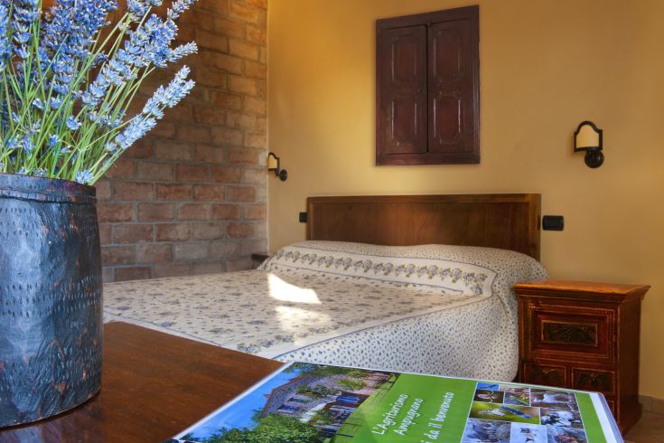 Chambre simple avec des meubles en bois et des décorations florales, donnant sur un beau panorama rural.