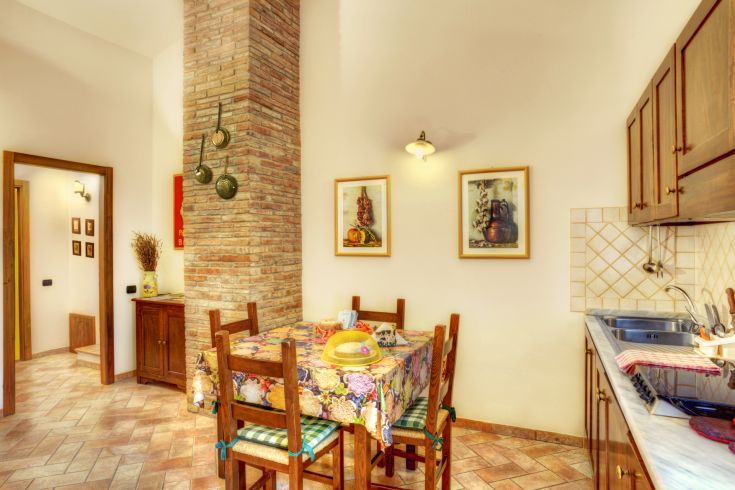 Cuisine simple avec une table à manger, des détails en bois et des décorations discrètes.