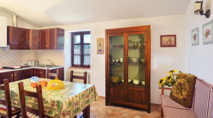 Intérieur fonctionnel d'une cuisine avec une table bien dressée et des meubles en bois bien entretenus.