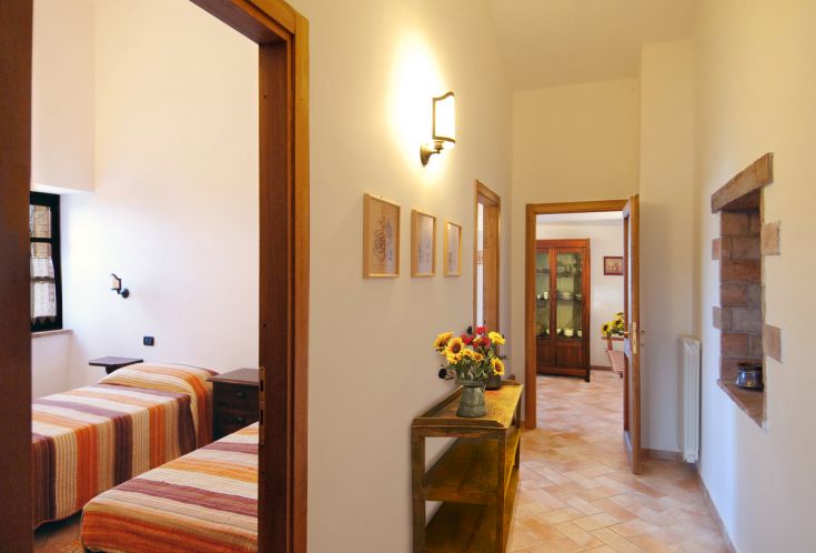 Un couloir simple menant à des chambres aux couleurs vives, aménagées avec soin pour le confort.