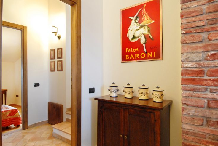 Un couloir décoré de style vintage avec un cabinet en bois et des objets en céramique.