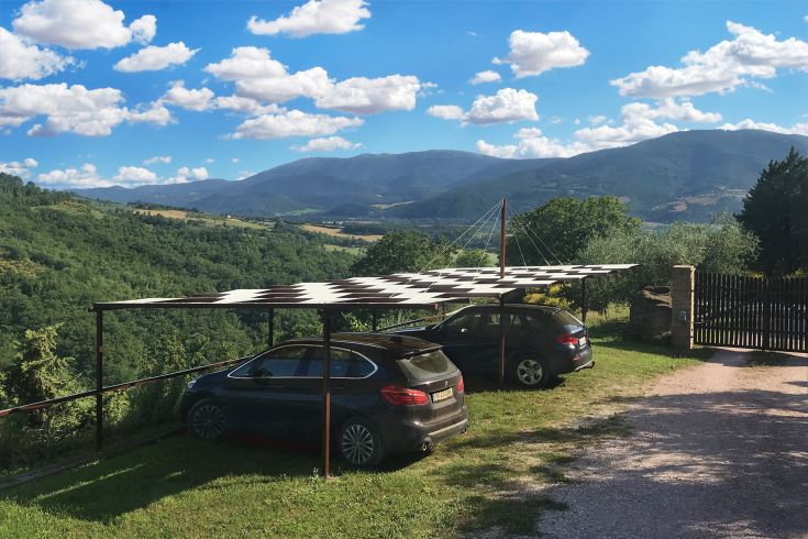 Un parking extérieur surplombant une scène de collines et de montagnes environnantes.