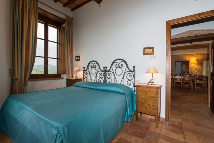 Spacious bedroom featuring a double bed and light wooden furniture.