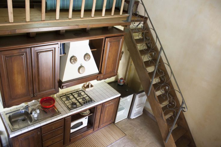 Cuisine en bois accueillante avec un escalier menant à l'étage, ambiance chaleureuse et confortable.