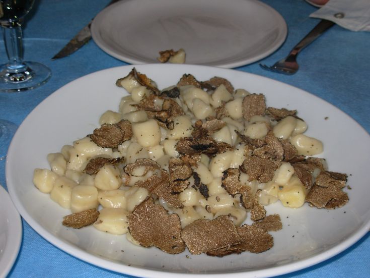 Gnocchi mit Trüffel, serviert in einem schlichten Ambiente, ein Gericht, das von Liebhabern authentischer Aromen geschätzt wird.