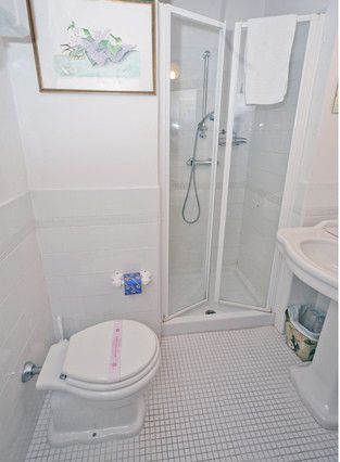 Einfaches Bad ausgestattet mit Dusche und Einrichtungen, entworfen um funktional und praktisch zu sein.