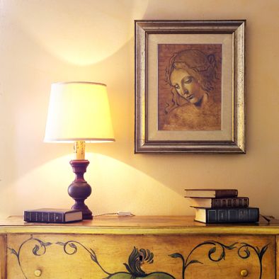 Ein ruhiger Lesebereich mit einer Lampe, einem Gemälde und mehreren Büchern, ideal zum Entspannen und Lesen.