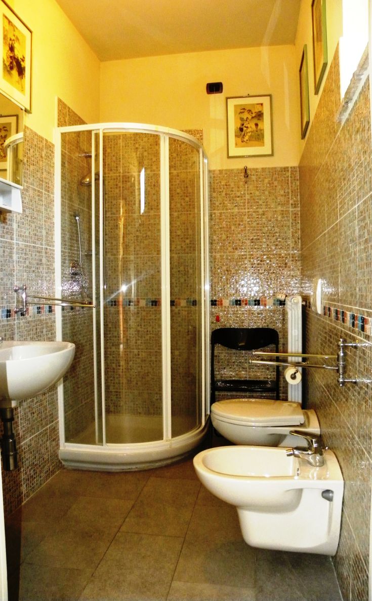 Simple bathroom with a shower, sink, and modern fixtures in a typical stone house of Umbria.