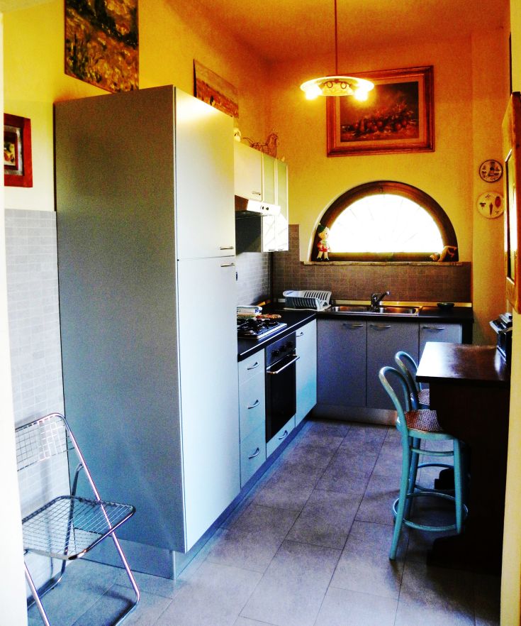 Modern and cozy kitchen with simple furnishings and a view of the Umbrian countryside.