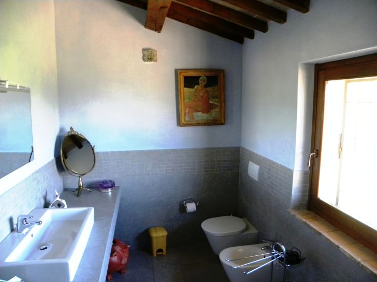 A bright and thoughtfully decorated bathroom overlooking a serene Umbrian hill.