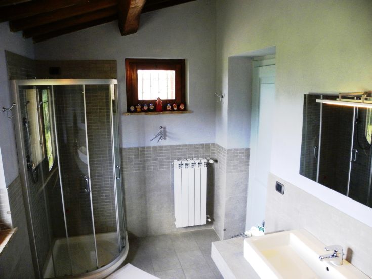 Modern bathroom interior, featuring a shower, sink, and simple line details.