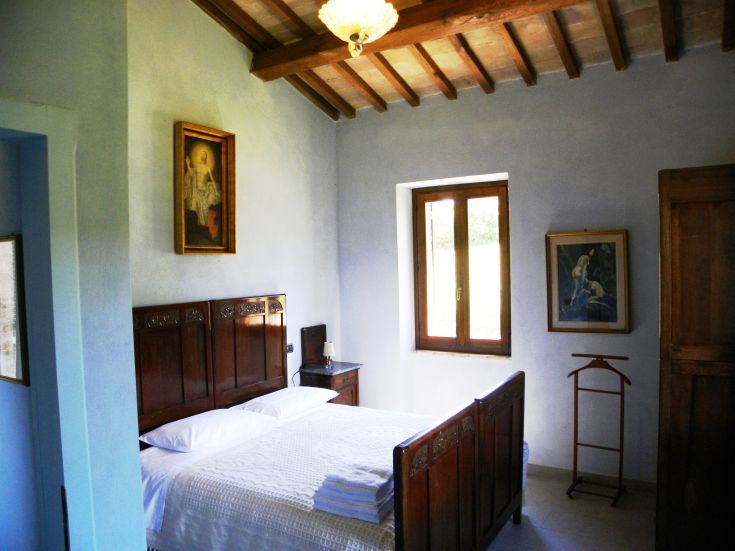 Simple room with wooden furniture and good lighting, located in a typical Umbrian agriturismo.
