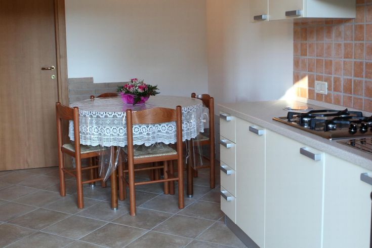 Cucina confortevole con tavolo apparecchiato e piante, adatta per momenti di condivisione in famiglia.