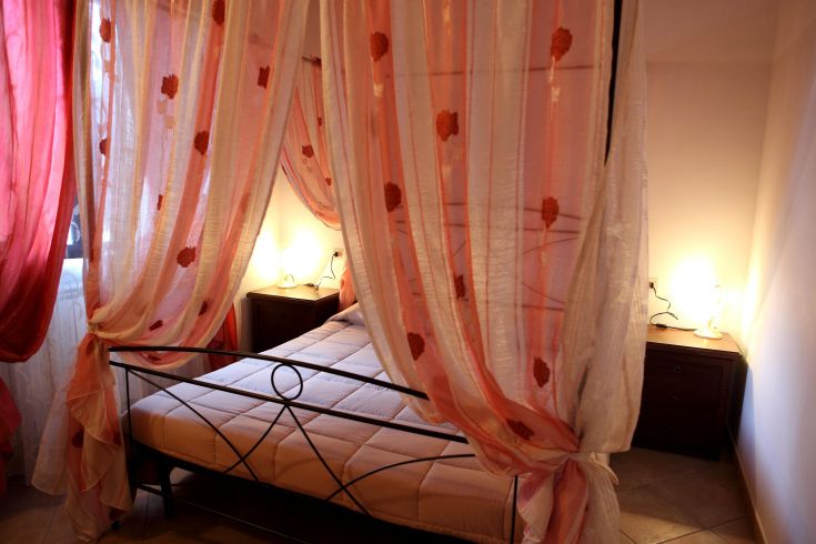 Stanza confortevole con tende sobrie e illuminazione delicata, ideale per momenti di relax.