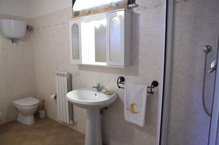 Bagno arredato in modo funzionale con piastrelle chiare, perfetto per momenti di relax.